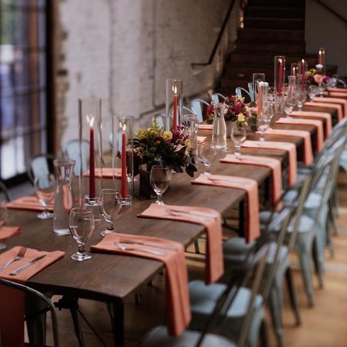 Long table with orange napkins and candles